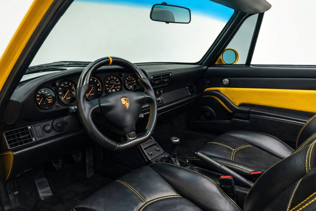 Interior of a 1995 Porsche 911 Strosek Cabriolet with black leather seats and yellow accents