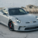 Porsche 911 GT3 in gray parked on urban pavement with black wheels and red brake calipers