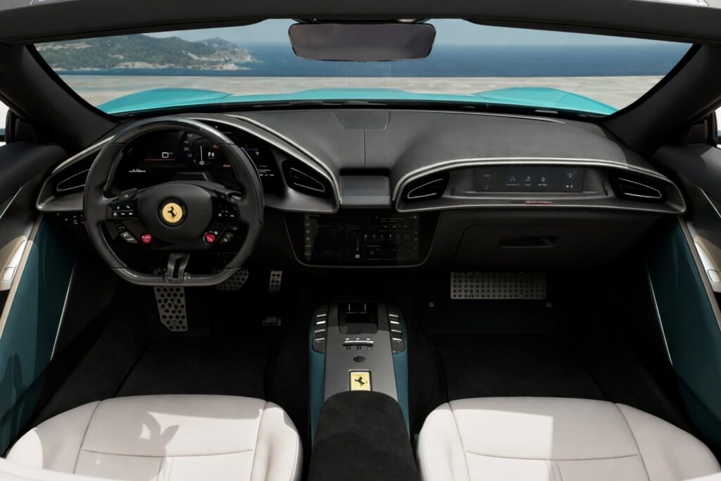 Luxury convertible interior with white leather seats and digital dashboard overlooking ocean coastline