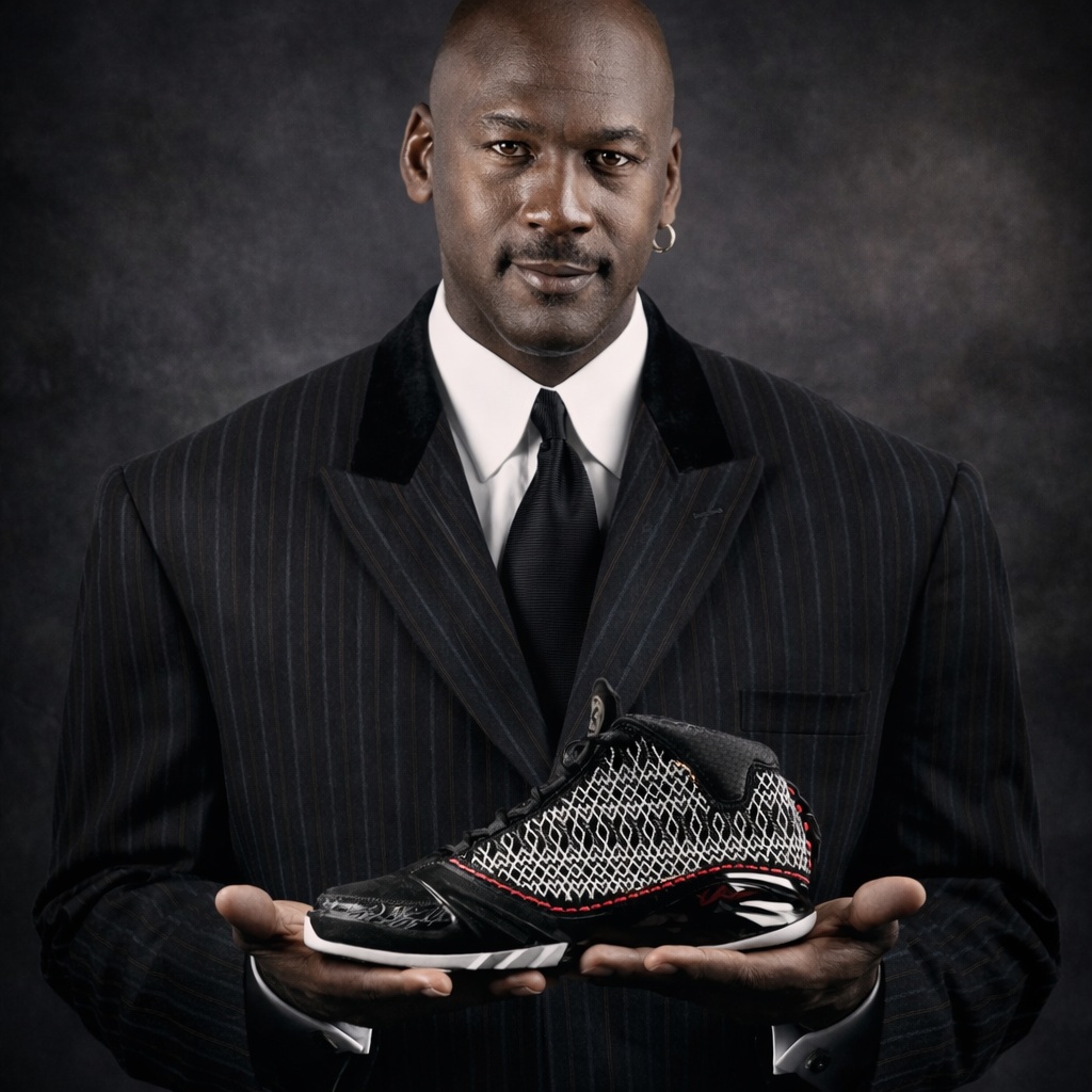 Michael Jordan holding Air Jordan sneaker in suit portrait with luxury branding aesthetic