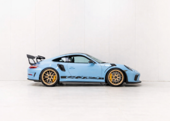 Blue Porsche 911 GT3 RS side profile in a clean studio setting with gold wheels and black aero accents