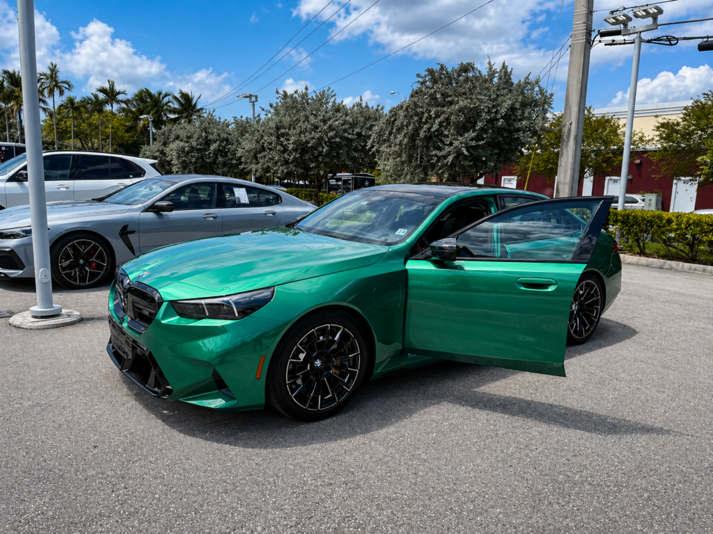 Green BMW M5 2025 front three quarter view parked outdoors