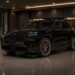 Porsche Cayenne Electric in luxury garage with wireless charging pad and titanium wheels