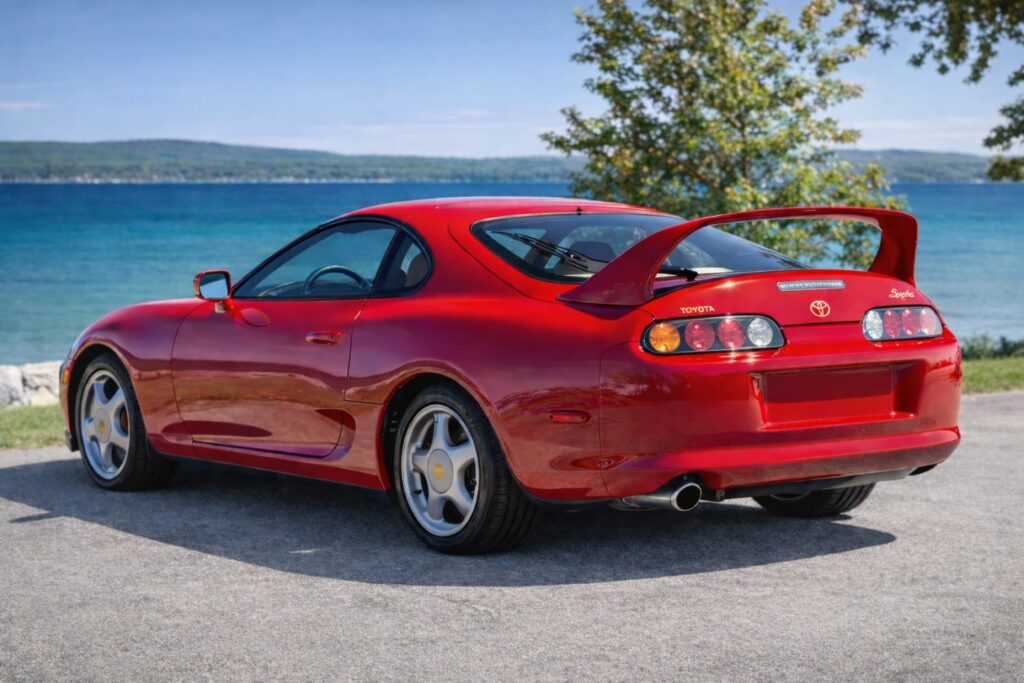 JDM legends Red Toyota Supra Mk IV parked by a lake with clean rear view and no license plate