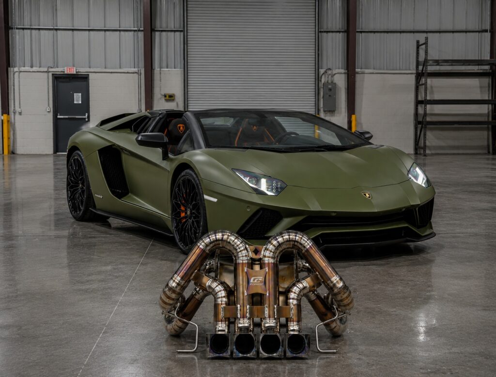 Matte green Lamborghini Aventador with titanium custom exhaust system inside industrial warehouse