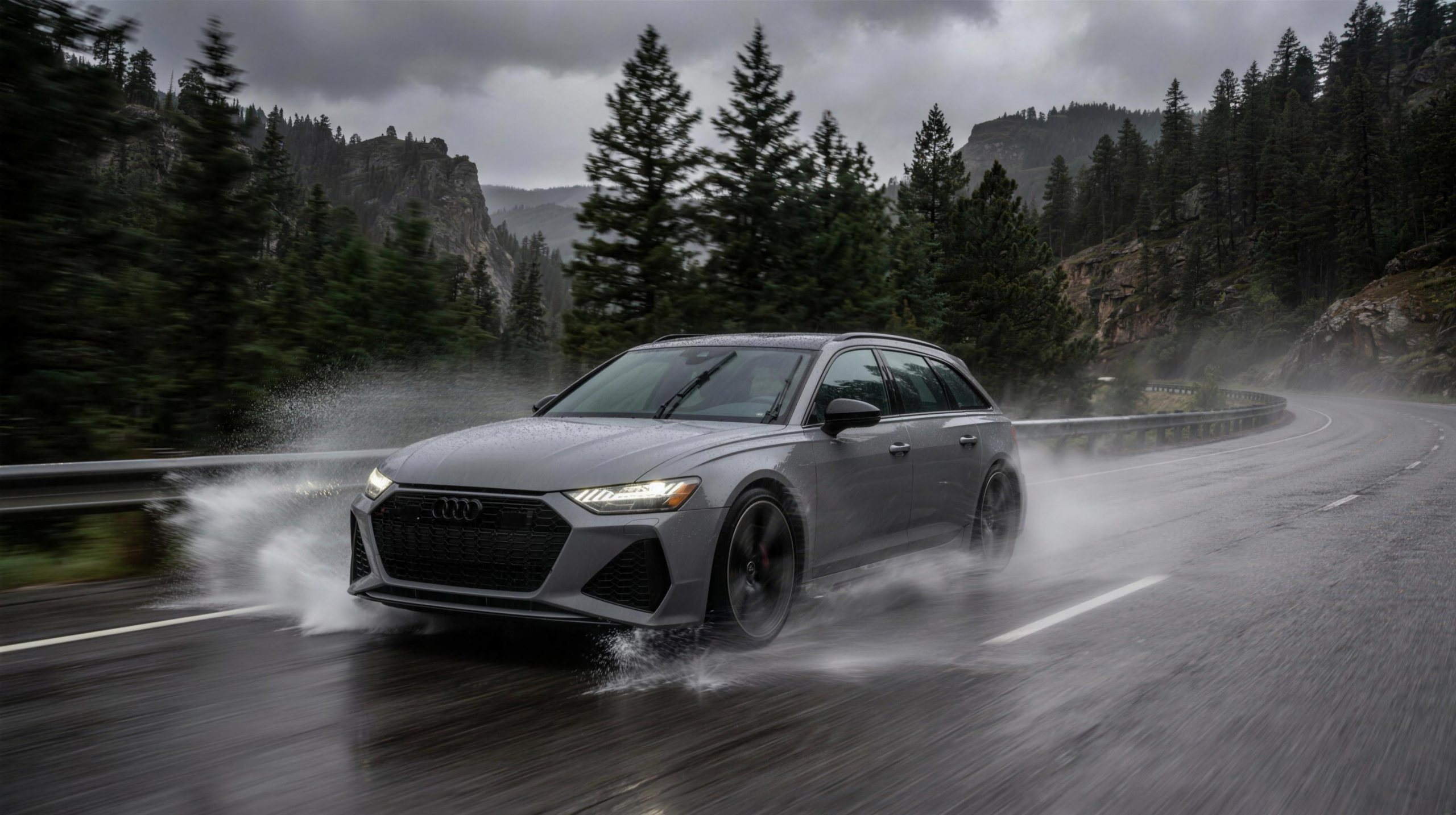 Audi RS6 Avant driving in heavy rain showing quattro all-wheel-drive grip