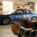 Collector holding a 1990s video game controller in front of a Japanese sports coupe in his garage