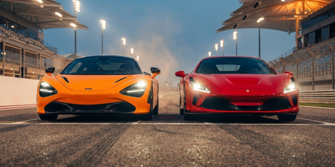 McLaren W1 and Ferrari F80 hypercars nose to nose on a racetrack at dusk
