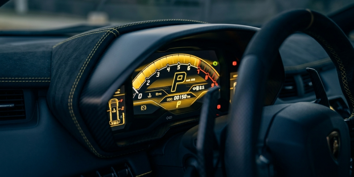 Exotic car digital instrument cluster showing odometer mileage readout
