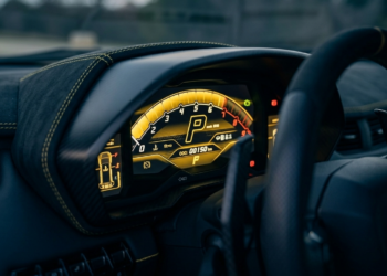 Exotic car digital instrument cluster showing odometer mileage readout