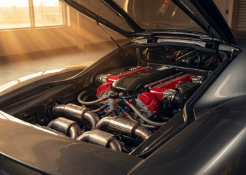 Engine bay of a modern naturally aspirated V12 supercar under workshop light