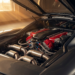 Engine bay of a modern naturally aspirated V12 supercar under workshop light