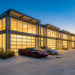Row of garage condo units at dusk with exotic cars parked outside