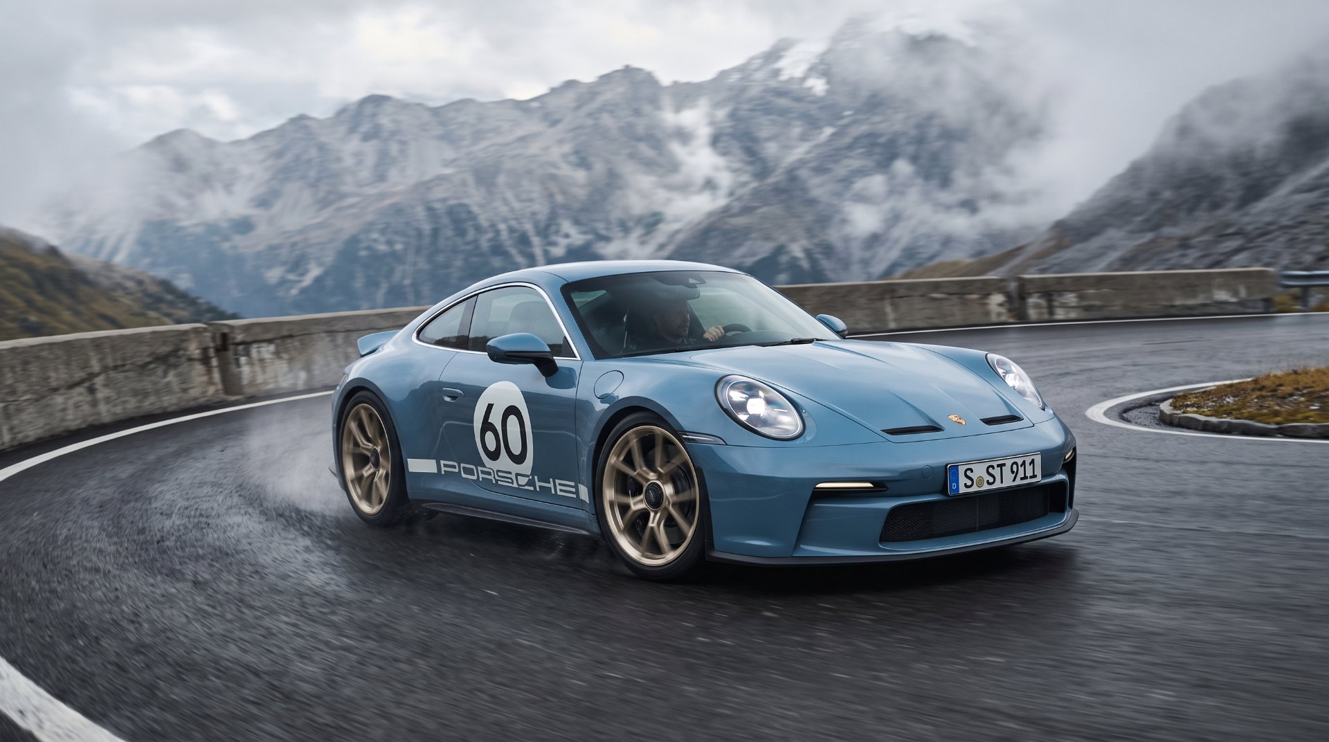 Porsche 911 S/T manual sports car cornering on an alpine pass, a sold-out icon of the analog comeback
