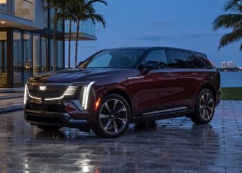 2026 Cadillac ESCALADE IQ front three-quarter view at dusk on a Miami waterfront driveway