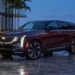 2026 Cadillac ESCALADE IQ front three-quarter view at dusk on a Miami waterfront driveway