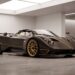 One-of-one supercar in exposed carbon fibre parked inside a supercar atelier before restoration