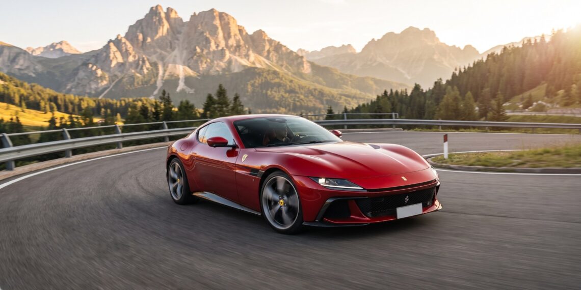 Red Ferrari 12Cilindri cornering on a Dolomites mountain pass at golden hour