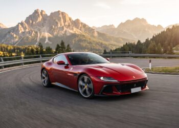 Red Ferrari 12Cilindri cornering on a Dolomites mountain pass at golden hour