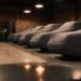A row of collector cars under fitted covers in a private garage, the kind of agreed-value coverage Hagerty insurance is built around