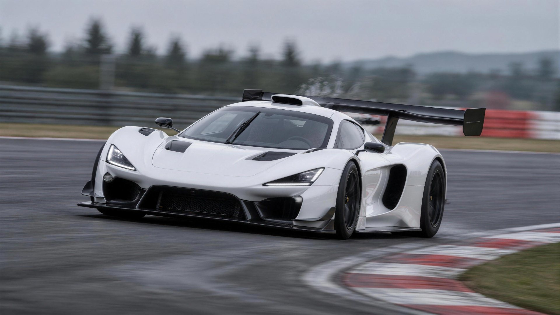 White track hypercar cornering at speed on a racing circuit, photographed with panning motion blur