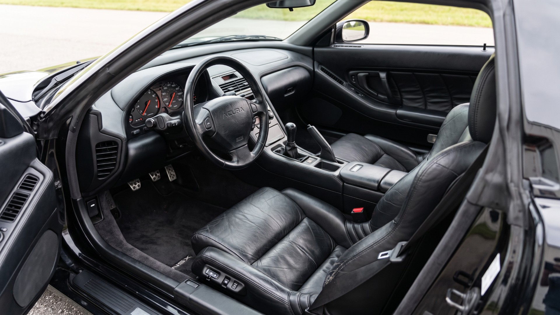 First-generation Acura NSX cabin with a manual gear lever, three pedals and analog gauges
