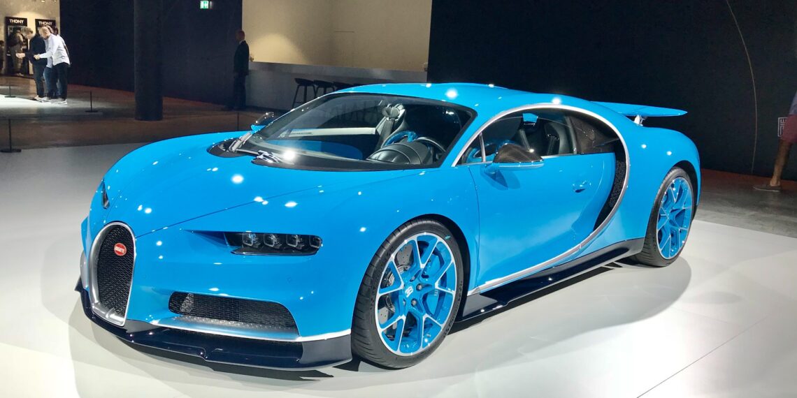 A blue Bugatti Chiron hypercar on display under spotlights