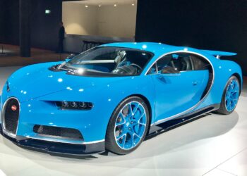 A blue Bugatti Chiron hypercar on display under spotlights