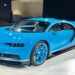 A blue Bugatti Chiron hypercar on display under spotlights
