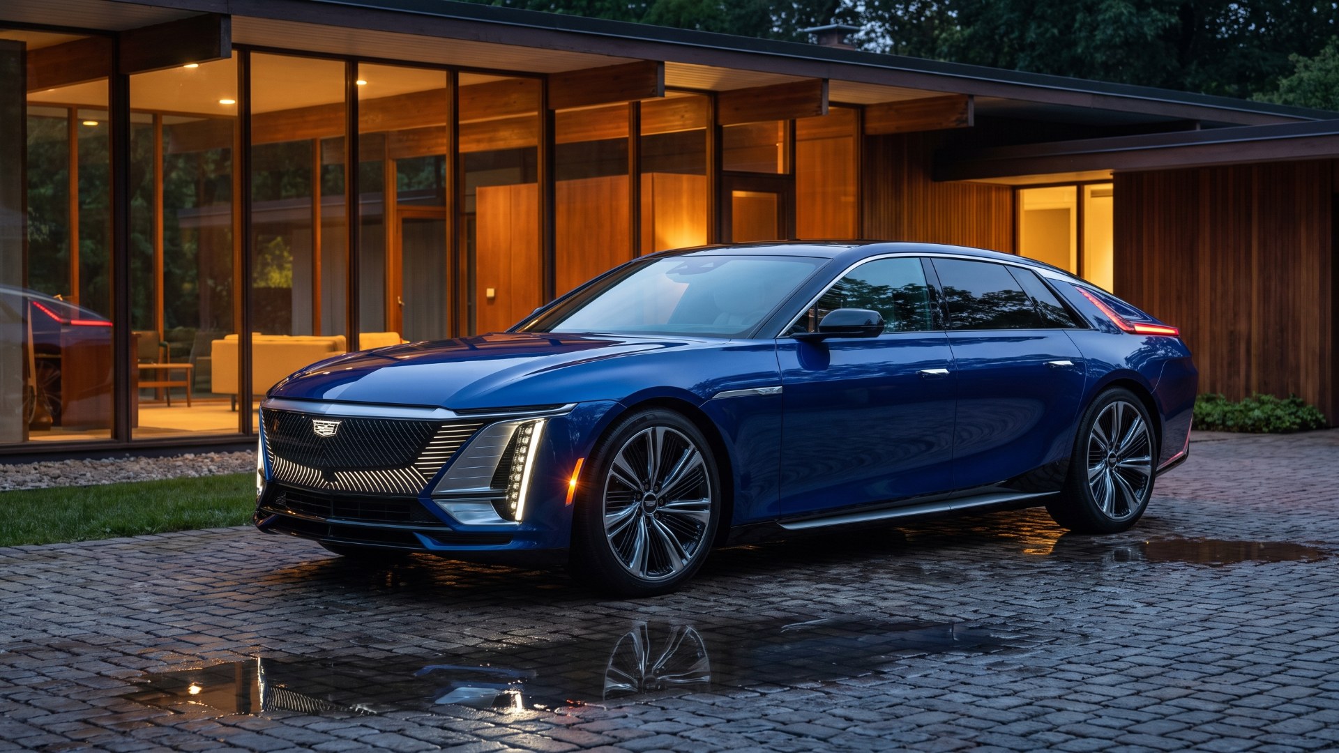 Dark blue Cadillac Celestiq parked on a wet cobblestone drive outside a glass-walled midcentury house at dusk