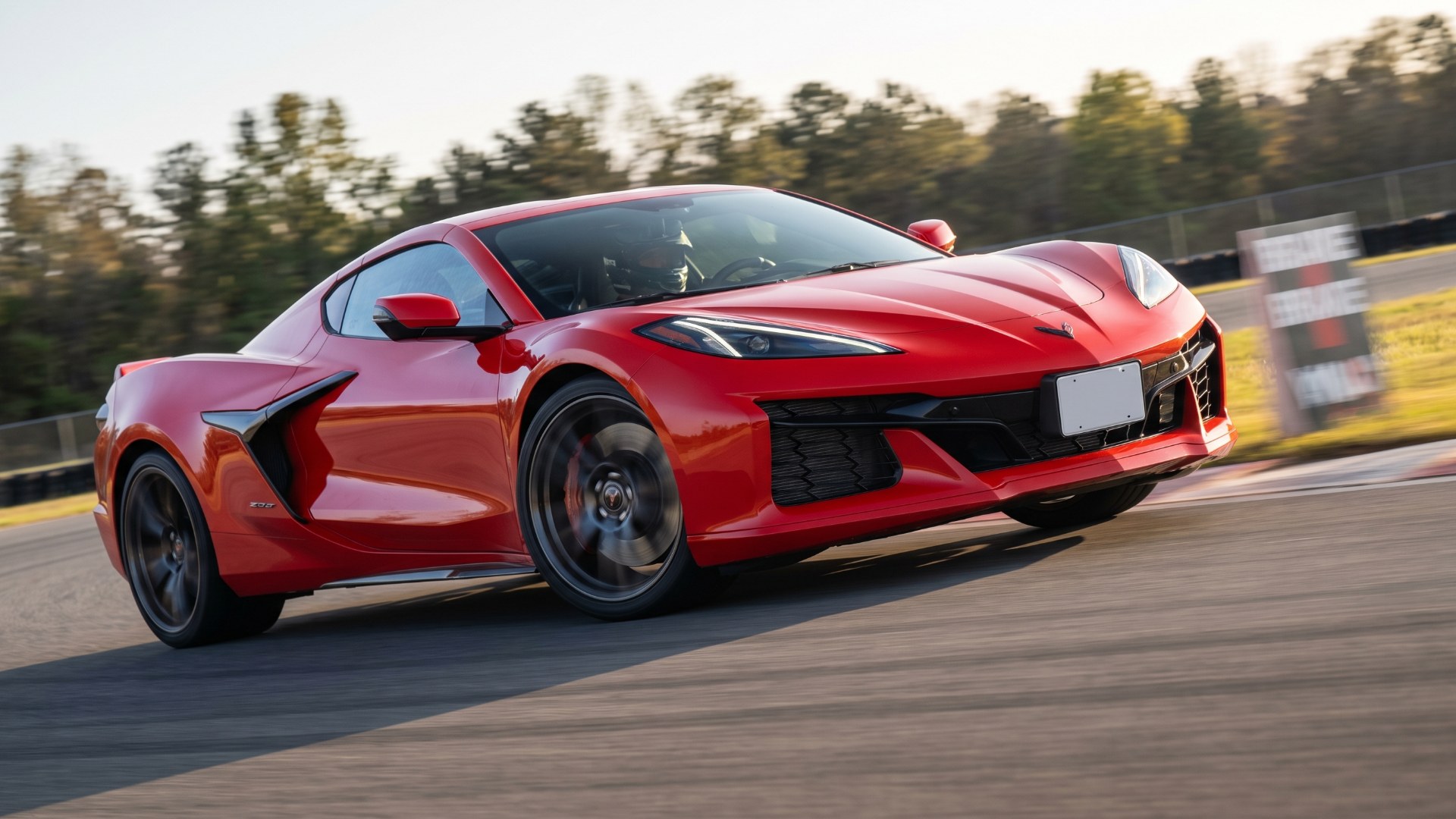 Red Chevrolet Corvette Z06 braking into a corner on a racetrack