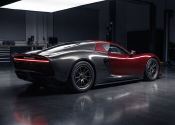 AI-generated illustration of a fictional mid-engine supercar prototype with exposed carbon-fiber rear bodywork in a development studio