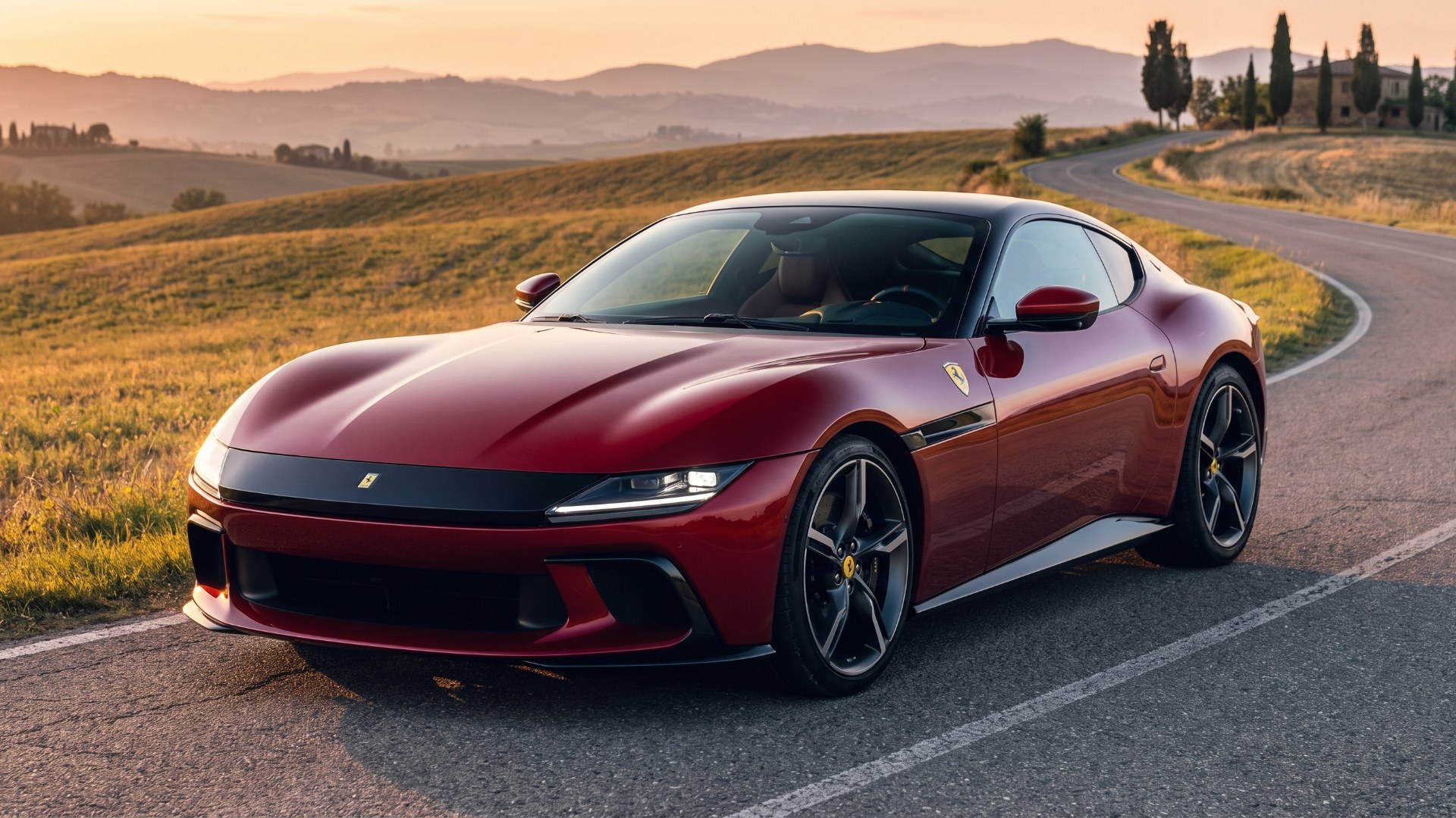 Dark red Ferrari 12Cilindri coupe parked on a hillside road at sunset, seen from the front three-quarter
