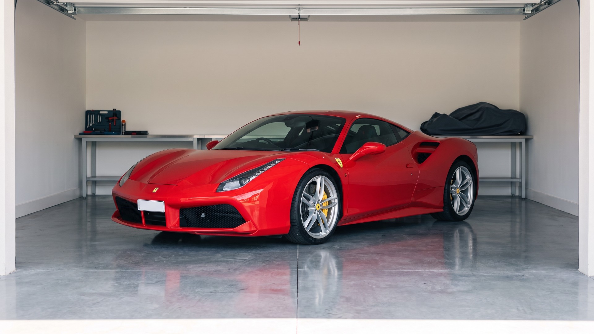 Red Ferrari 488 GTB coupe parked in a home garage