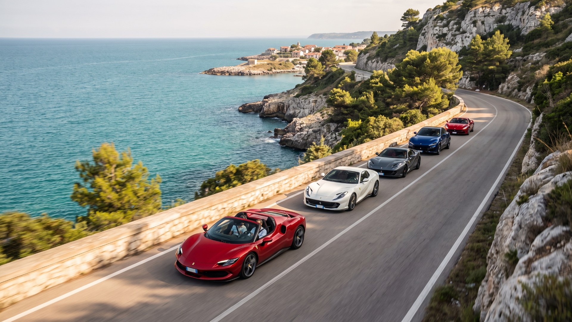 Five Ferraris led by a red 296 GTS drive in line along a cliffside road above the sea