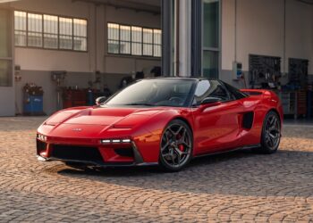 Red JAS Tensei with a black roof and widened carbon bodywork, front three-quarter view in a workshop courtyard