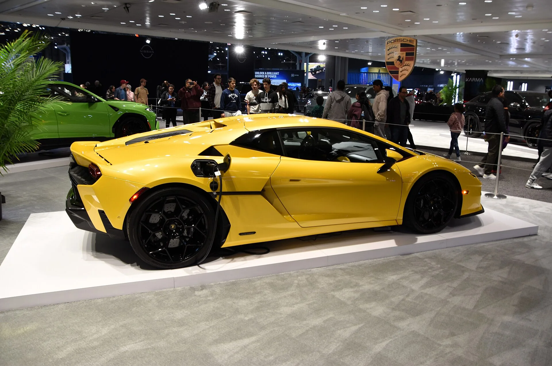 Yellow Lamborghini Temerario with a body-color roof on an auto show stand, side view