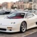Ivory-white MCA Centenaire supercar parked on a harbor quay in Monaco