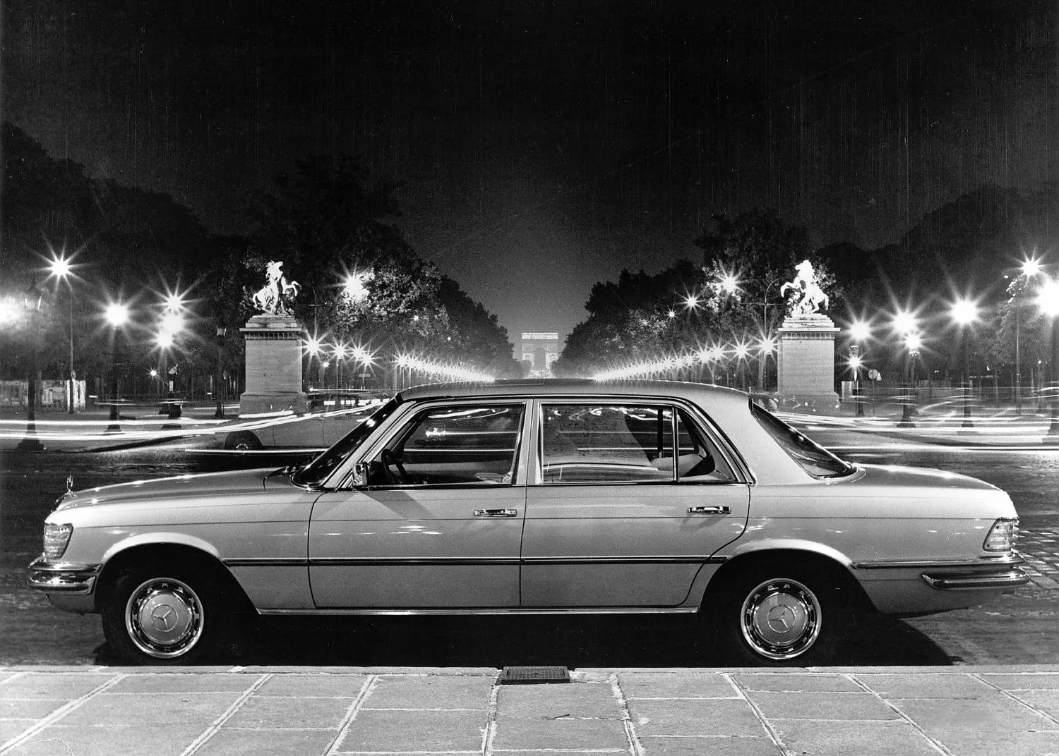 Black-and-white photo of a Mercedes-Benz 450 SEL W116 sedan parked on a Paris street