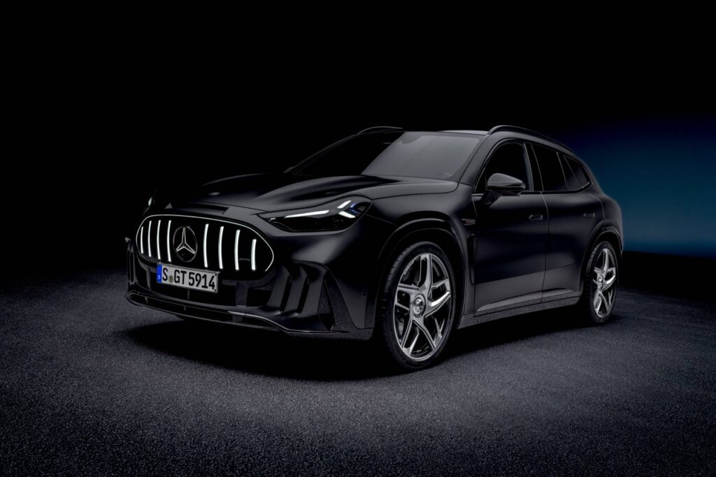 Front three-quarter view of a black Mercedes-AMG GT SUV with illuminated grille, in a dark studio