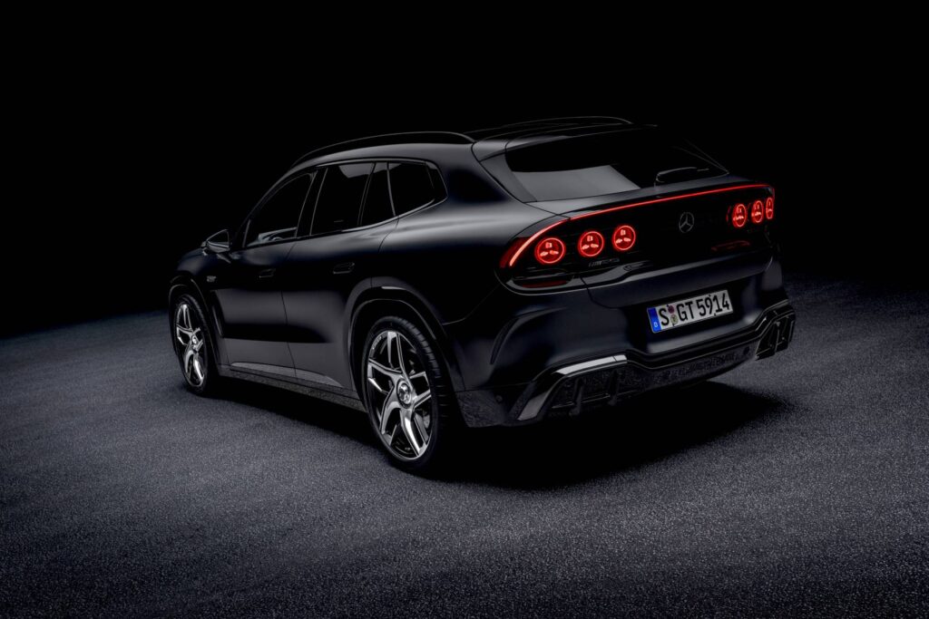 Rear three-quarter view of a black Mercedes-AMG GT SUV showing its round taillights, in a dark studio