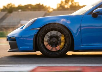 Porsche 911 GT3 braking on a race track, its yellow caliper clamping a grey carbon-ceramic disc