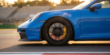 Porsche 911 GT3 braking on a race track, its yellow caliper clamping a grey carbon-ceramic disc