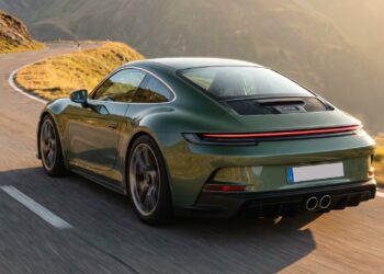 Green Porsche 911 GT3 Touring driving on an alpine road, seen from the rear