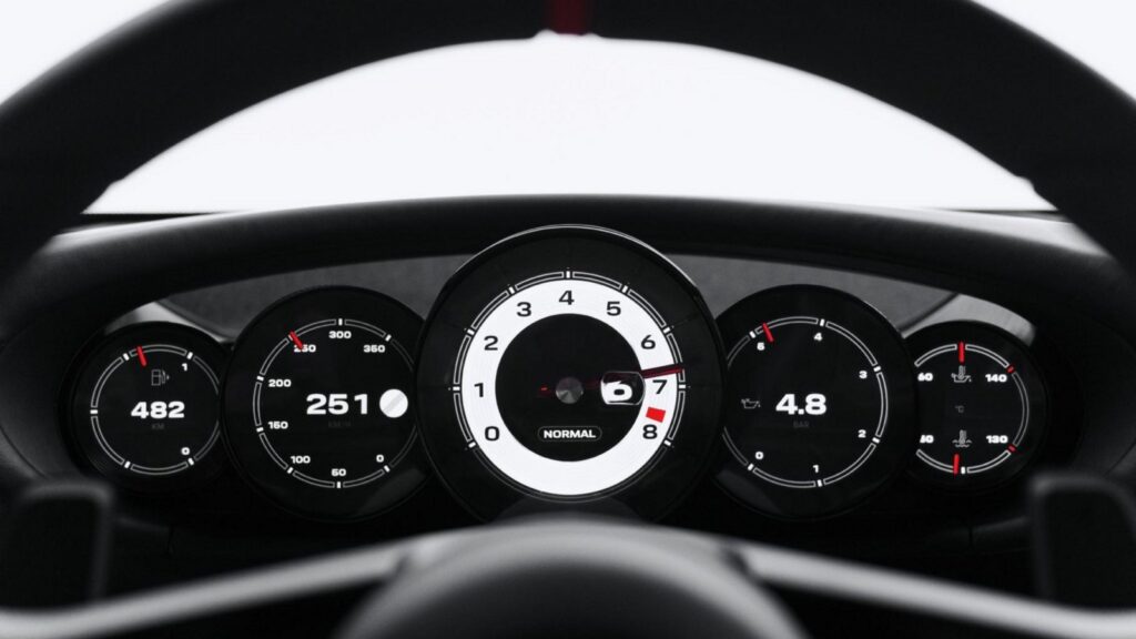 Five round instrument dials behind the Mission S steering wheel, with a central tachometer