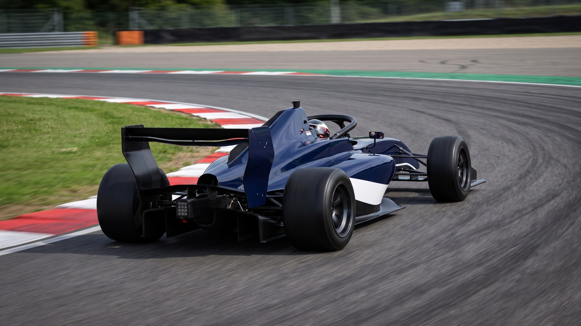 Illustration of a navy blue RYN FP3 with four wheels cornering on a racetrack