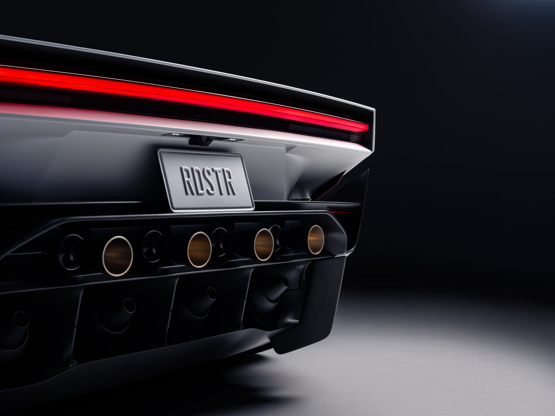 Rear diffuser of the Tesla Roadster showing a row of circular outlets below the license plate